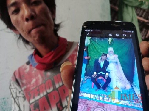 Sandi saat menunjukkan foto pernikahannya dengan Faunatul Fidayah. (Foto : Adi Rosul / JombangTIMES)