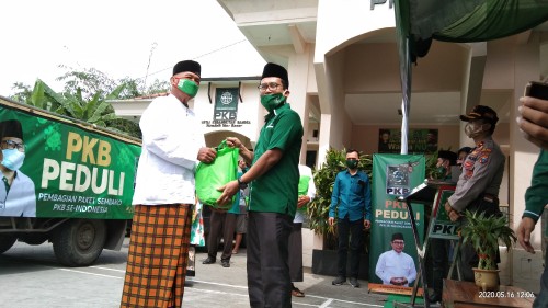 Adib Makarim (baju hijau) saat menyerahkan bantuan secara simbolis pada guru ngaji (Joko Pramono for Jatim TIMES)