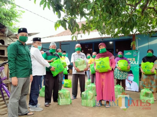 Ketua DPC PKB Kota Blitar Yasin Hermanto menyerahkan simbolik bantuan sembako kepada warga terdampak Covid-19.(Foto : Aunur Rofiq/BlitarTIMES)