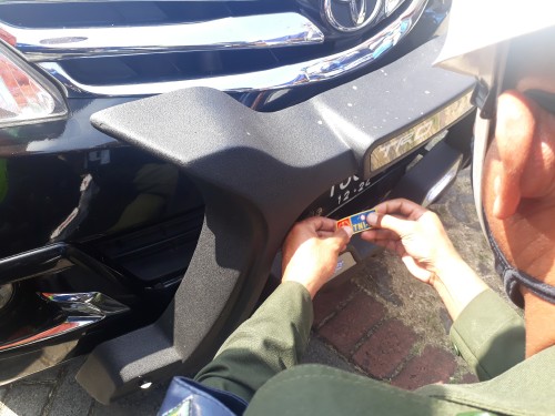 Petugas Polisi Militer (PM) sedang mengambil tindakan mencabut stiker dari kesatuan TNI AU yang berada di plat nomor mobil masyarakat sipil di Check Point Bakpau Telo Lawang, Minggu (17/5/2020). (Foto: Tubagus Achmad/MalangTimes)