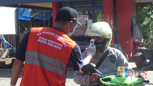 Petugas kesehatan saat memeriksa kondisi masyarakat yang melintasi kawasan PSBB di Kota Malang. (Ahmad Nur Amin/MalangTIMES).
