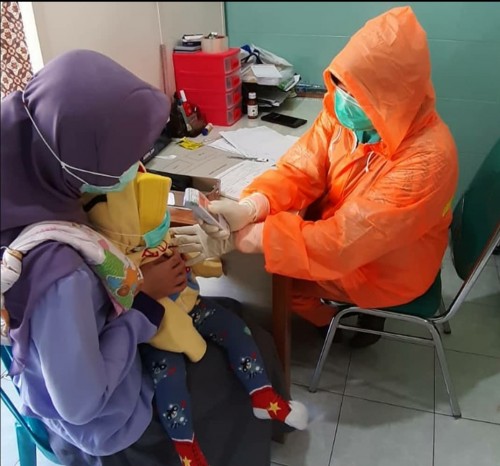Petugas Kesehatan di Puskesmas Kendalkerep saat memberikan layanan pada balita. (Foto: instagram @puskesmaskendalkerep).