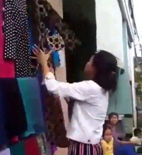Salah seorang warga yang tengah memilih baju untuk diambil dengan gratis. (Foto: source twitter).