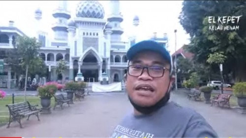 El Kepet saat vlog menceritakan tradisi Blanggur di depan Masjid Jami' (screenshot YouTube)
