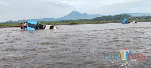 Dua truk yang terseret banjir dikawasan tambang Pandan Arum (Foto : Moch. R. Abdul Fatah / Jatim TIMES)