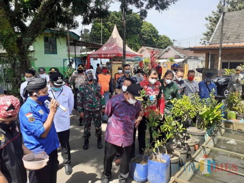 Menko PMK Muhadjir Effendy (bertopi, batik ungu) saat melakukan kunjungan ke Kampung Tangguh Semeru RW 05, Kelurahan Purwantoro, Kecamatan Blimbing, Kota Malang, Rabu (3/6).(Arifina Cahyanti Firdausi/MalangTIMES).