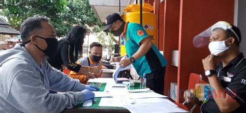Suhani (kiri) saat mencari SIKM di Posko Covid 19 Tulungagung (Joko Pramono for JatimTIMES)