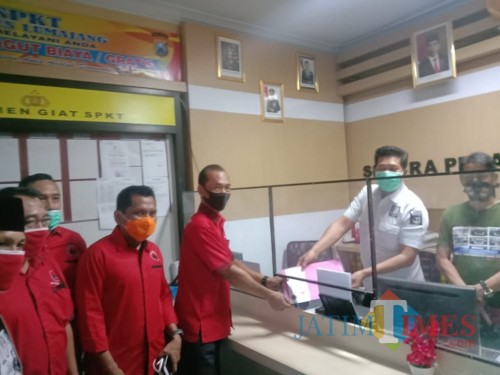 Solikin SH ketika menyerahkan laporan ke Polres Lumajang (Foto : Moch. R. Abdul Fatah / Jatim TIMES)