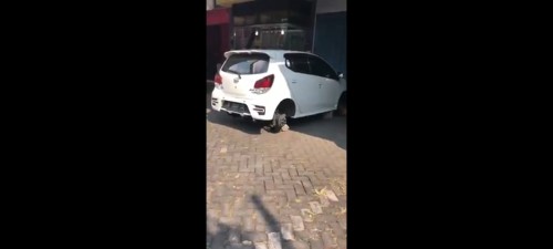 Mobil Ayla yang terparkir dengan velg dan ban yang telah dicuri. (Ist)