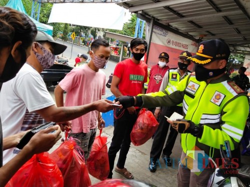 Beberapa pemuda saat akan mengumpulkan sampah kepada petugas saat patroli di Pasar Besar Kota Batu, Minggu (5/7/2020). (Foto: istimewa)