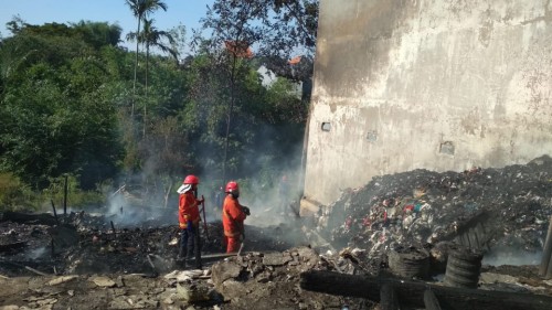 Lokasi gudang barang bekas yang terbakar, nampak petugas terus berupaya memadamkan api (Ist)