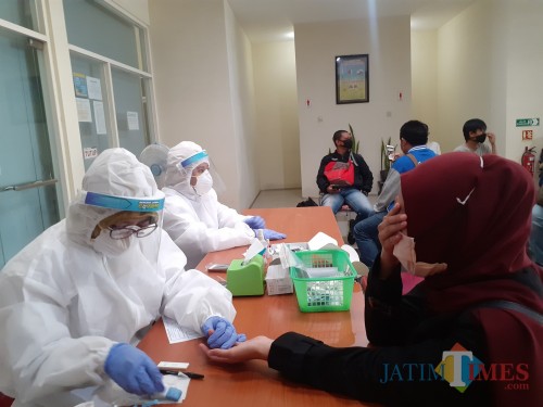Petugas Kesehatan dari Dinkes Kota Malang saat melakukan rapid test kepada seorang warga. (Arifina Cahyanti Firdausi/MalangTIMES).