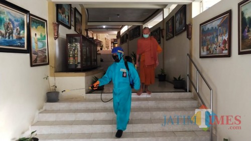 Salah satu anggota Tagana Kota Batu melakukan menyemprotan di vihara Desa Mojorejo, Kecamatan Junrejo, Jumat (10/7/2020). (Foto: istimewa)
