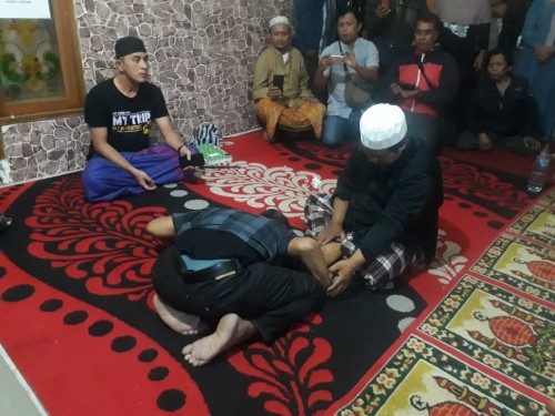 Gus Idris dengan Kyai Rodyallah sedang menangani pasien dari daerah Tuban yang datang ke Ponpes Thoriqul Jannah, Ngajum, Kabupaten Malang, Sabtu (11/7/2020) dini hari. (Foto: Tubagus Achmad/MalangTimes)