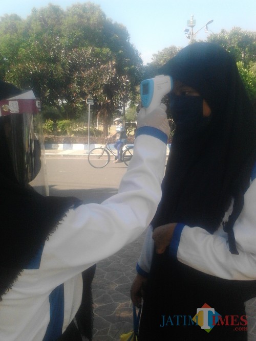 Sebelum masuk lingkungan sekolah, siswa diperiksa suhu tubuh