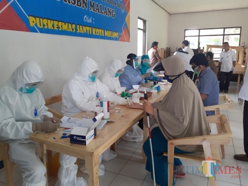 Petugas kesehatan dari Puskesmas Janti saat melakukan rapid test terhadap warga RSBN Malang, Rabu (15/7). (Arifina Cahyanti Firdausi/MalangTIMES).