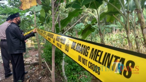 Polisi memasang police line di lokasi ditemukanya mayat Sadak.(Foto : Aunur Rofiq/BlitarTIMES)