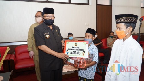 Wali Kota Blitar Santoso secara simbolik menyerahkan sejumlah bantuan kepada peserta sunatan masal.(Foto : Aunur Rofiq/BlitarTIMES)