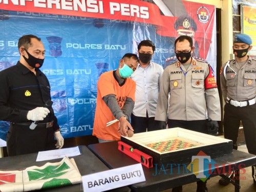 Tersangka saat mempraktikkan cara menggelindingkan bola saat rilis di Polres Batu, Kamis (30/7/2020). (Foto: Irsya Richa/MalangTIMES)