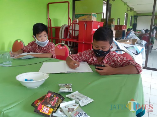 Para siswa SD saat menjalani sekolah daring dengan memanfaatkan wifi gratis di Kelurahan Bandulan, Kecamatan Sukun, Kota Malang, Selasa (4/8). (Arifina Cahyanti Firdausi/MalangTIMES).