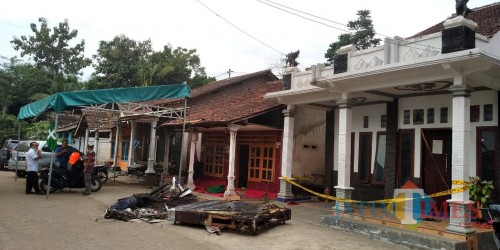 Polisi memasang garis polisi di rumah korban untuk melakukan penyelidikan terhadap kematian Nurhasiti (foto: M Setyo W/ JatimTIMES)