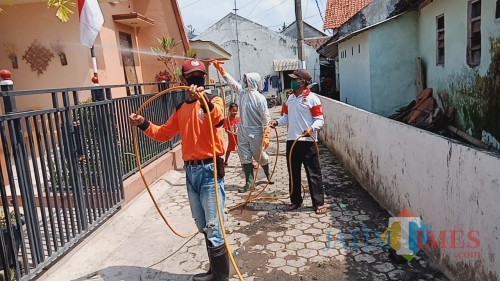 Relawan PMI Kabupaten Jember saat melakukan penyemprotan disinfektan di rumah-rumah warga (foto: Puji SN / JatimTIMES)
