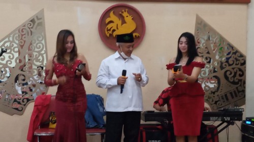 Sanusi saat bernyanyi diatas panggung dengan didampingi dua penyanyi dangdut (Ist)