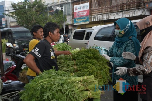 TP PKK Kabupaten Jember saat membagikan masker kepada pedagang pasar Tanjung (foto : Istimewa / Jatim TIMES)