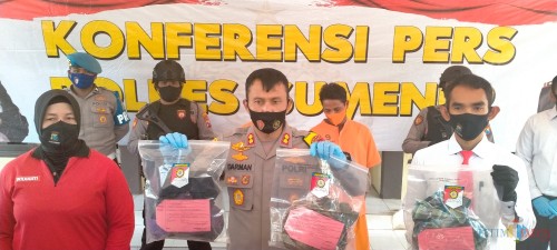 Polisi saat menunjukkan barang bukti dan menghadirkan dua pelaku pembunuhan. (Foto: Syaiful Ramadhani/JatimTIMES)