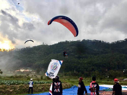 Bendera Arema saat diterbangkan oleh penerbang paralayang di Lapangan Songgomaruto, Kelurahan Songgokerto, Kecamatan Batu, Selasa (11/8/2020). (Foto: Irsya Richa/MalangTIMES)
