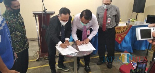 Direktur PDAM Jember Ady Setiawan bersama Pemimpin Bank Jatim Syariah Jember Solehudin saat menandatangani MoU. (foto : Moh. Ali Makrus / Jatim TIMES)