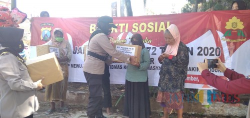 AKP. Yuliati Suviani saat membagikan paket Sembako kepada warga yang jualan di trotoar Jembatan Semanggi (foto : Moh. Ali Makrus / JatimTIMES)