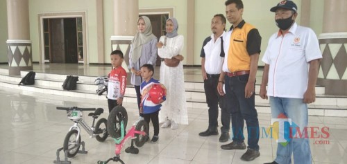 Kelvin Ibnu Putra (paling kiri) saat dilepas oleh ketua KONI Jember untuk bertanding Pushbike di Kota Malang (foto : Moh. Ali Makrus / Jatim TIMES)