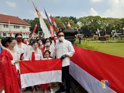Wakil Wali Kota Malang Sofyan Edi Jarwoko (paling kanan) saat serah terima pembentangan bendera merah putih sepanjang 366 meter di Alun-Alun Tugu Kota Malang, Minggu (16/8). (Arifina Cahyanti Firdausi/MalangTIMES).