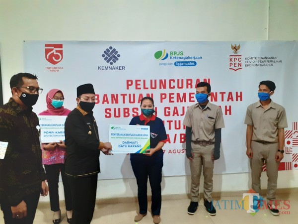 Wali Kota Malang Sutiaji (berkopiah) saat menyerahkan bantuan subsidi secara simbolis kepada pekerja di Kota Malang, di Kantor BPJS Ketenagakerjaan Cabang Malang, Kamis (27/8). (Arifina Cahyanti Firdausi/MalangTIMES).