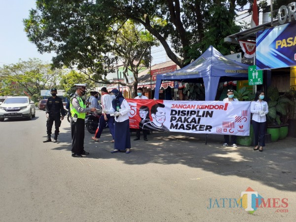 Petugas dari Polkesma saat membagikan masker kepada pedagang di Pasar Oro-Oro Dowo Kota Malang, Kamis (27/8). (Arifina Cahyanti Firdausi/MalangTIMES).