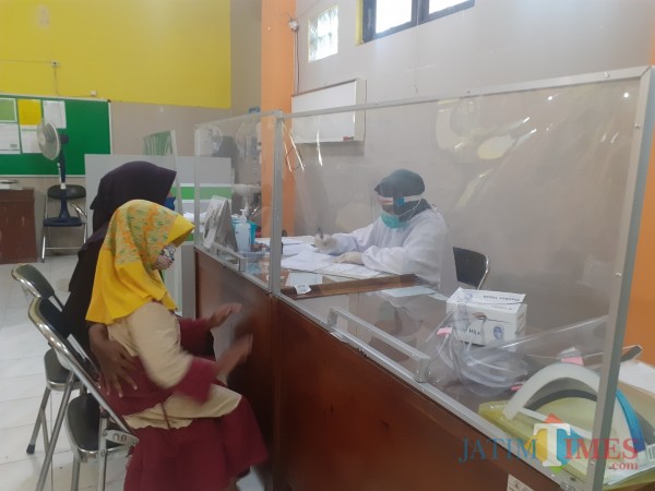 Pelayanan pasien di Puskesmas Kedungkandang dengan protokol Covid-19. (Arifina Cahyanti Firdausi/MalangTIMES).