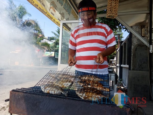 Joko Fattah Rachim saat mengolah ikan laut dengan cara diasap. (Foto : Adi Rosul / JombangTIMES)