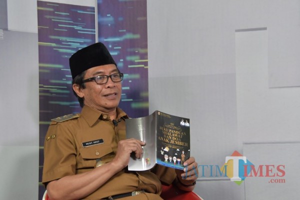Wakil Bupati Jember Drs KH A. Muqit Arief saat menunjukkan Buku Panduan Sholawat dan Doa Anak Jember. (foto : istimewa / Jatim TIMES)