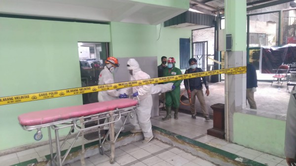 Petugas saat tengah melakukan evakuasi jasad korban dari dalam kamar bengkel (Ist)