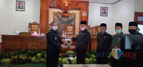 Bupati Tulungagung Maryoto Birowo (kiri, masker putih) menerima penetapan Perubahan APBD dari Marsono. (foto : Joko Pramono/Jatim Times)