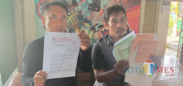 Entor (42) Warga Desa Kombang, Kecamatan Talango didampingi LSM Brantas saat menunjukkan bukti laporan di Kejari (Foto: Syaiful Ramadhani/JatimTIMES)