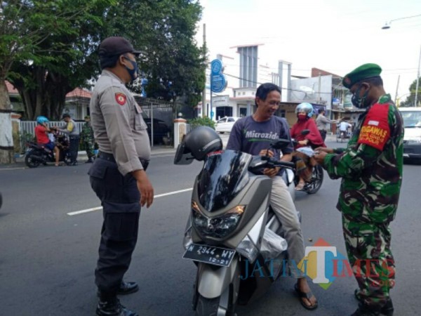 Anggota Polsek dan Koramil Kota Lumajang bagi masker kepada warga (Foto : Moch. R. Abdul Fatah / Jatim TIMES)