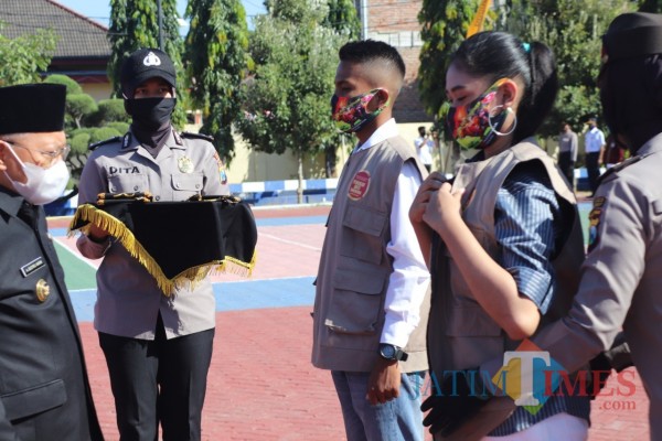Bupati Sumenep A. Busyro Karim saat memakaikan masker dan rompi pada duta anti narkoba di Mapolres Sumenep (Foto: Humas Polres Sumenep for JatimTIMES)