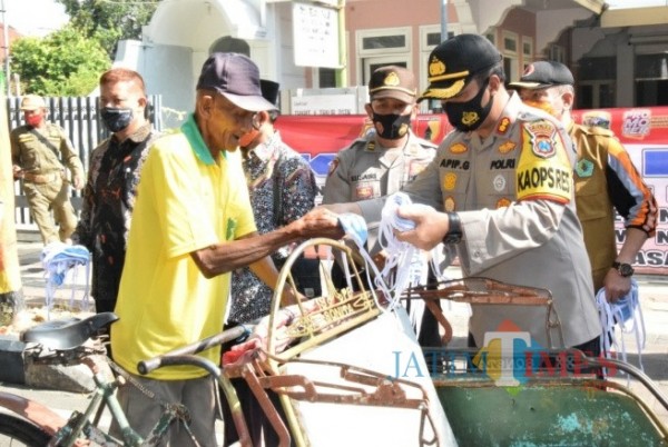 Kapolres Pamekasan Apip Ginanjar saat bagikan masker kepada masyarakat di Pamekasan, Foto: Rozy