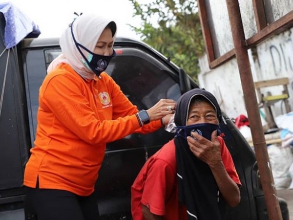 Wali Kota Batu Dewanti Rumpoko saat memasangkan masker kepada lansia di pinggi jalan Kota Batu. (Foto: instagram Dewanti_Rumpoko)