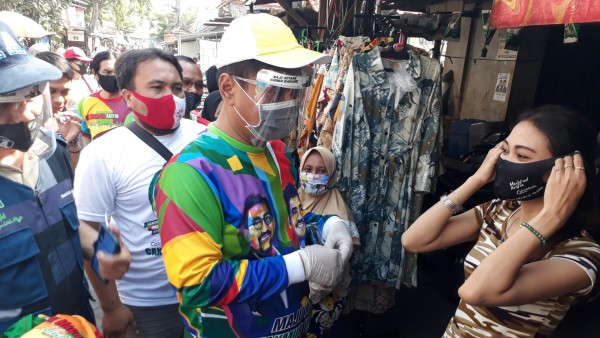 Mujiaman Sukirno saat membagikan masker ke warga