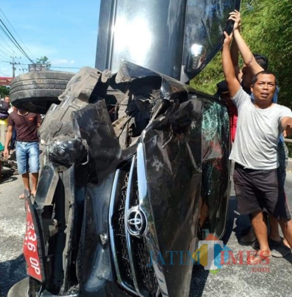 Polisi dan warga mengevakuasi mobil pelat merah yang terlibat kecelakaan di Jeblog, Talun.