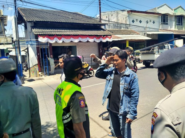Salah satu warga yang terjaring operasi yustisi disanksi menyanyikan lagu Indonesia dengan melakukan penghormatan (Anggara Sudiongko/MalangTIMES)
