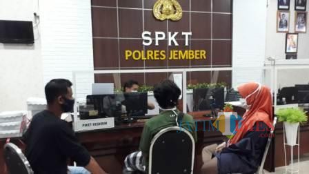 DSR (jilbab oranye) saat melaporkan kejadian yang dialaminya di Mapolres Jember. (foto : sid / Jatim TIMES)